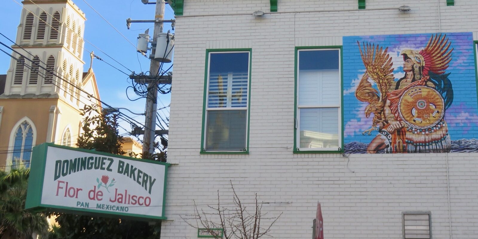A large, colorful mural painted on the side of a neighborhood building.